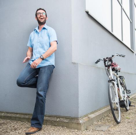 Man leunt tegen muur en zijn fiets staat om de hoek