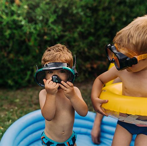 Kinderen met duikbril staan in een zwembadje