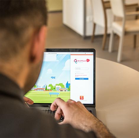 Verzorgende Mohammed zit achter de computer 