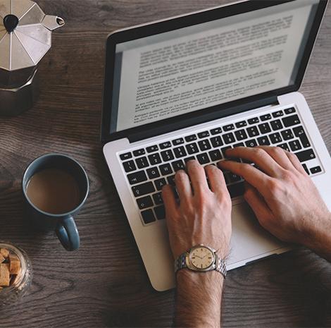 een paar handen typt op een laptop 