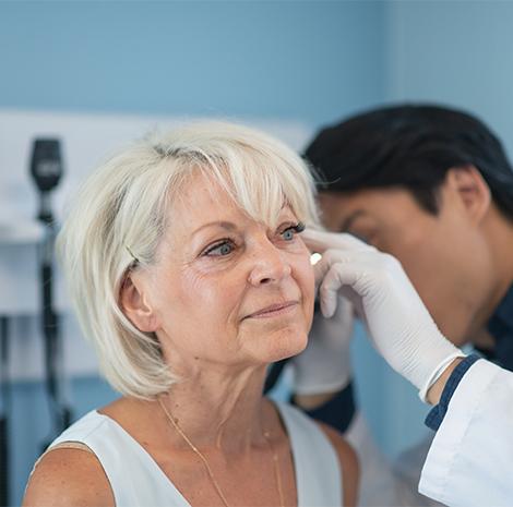 dokter kijkt in de oren van vrouw