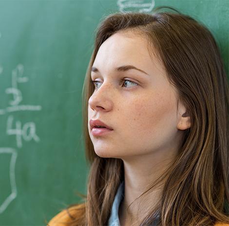 Meisje leunt tegen het schoolbord 