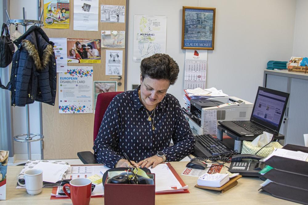 Maatschappelijk werker Sandra doet papierwerk aan haar bureau 