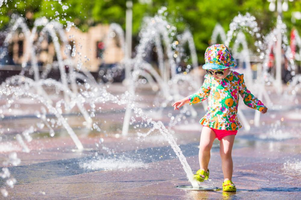 kind speelt met water tijdens hittegolf
