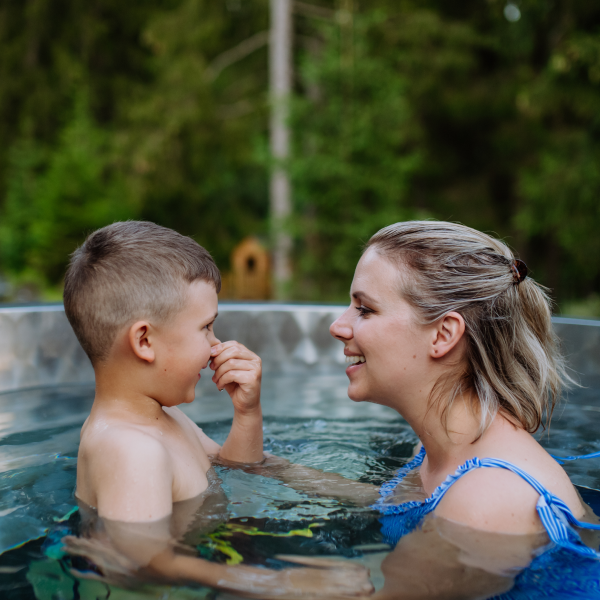 Een mama zit met haar zoontje in de jacuzzi