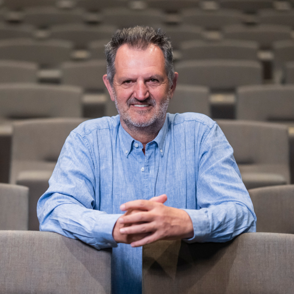 Patrick Van Gompel zit in een theaterzaal en kijkt in de lens